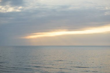 Gün batımında Baltık kıyılarından panoramik hava manzarası. Dramatik bulutlar, parlayan bulutlar, fırtınadan sonra altın güneş ışığı. Doğa, çevre, iklim değişikliği, kararsız hava