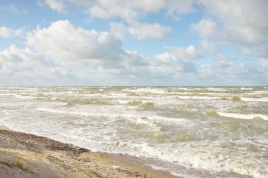 Fırtınadan sonra Baltık kıyıları (kum tepeleri, plaj). Dramatik gökyüzü, parlayan bulutlar. Resimli panoramik manzara. Doğa, çevre, ekoloji, eko-turizm, yürüyüş, keşif kavramları