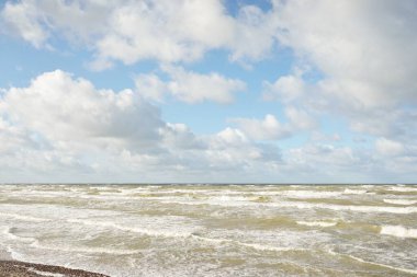 Fırtınadan sonra Baltık kıyıları (kum tepeleri, plaj). Dramatik gökyüzü, parlayan bulutlar. Resimli panoramik manzara. Doğa, çevre, ekoloji, eko-turizm, yürüyüş, keşif kavramları