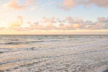 Deniz dalgaları ve sıçrama dokusu. Renkli gökyüzü suya yansıyor. Idyllic deniz manzarası. Kavramsal görüntü, uzun pozlama. Resimli bir manzara var. Arkaplan, duvar kağıdı, doğal desen, grafik kaynakları