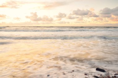 Deniz dalgaları ve sıçrama dokusu. Renkli gökyüzü suya yansıyor. Idyllic deniz manzarası. Kavramsal görüntü, uzun pozlama. Resimli bir manzara var. Arkaplan, duvar kağıdı, doğal desen, grafik kaynakları
