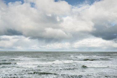 Fırtınadan sonra dramatik günbatımı bulutları altında Baltık Denizi. Dalgalar, su sıçratma. Destansı deniz manzarası. 40-50 deniz mili rüzgar gücü. Kasırga, fırtına, sert hava, meteoroloji, ekoloji, iklim değişikliği