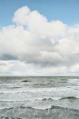 Fırtınadan sonra dramatik günbatımı bulutları altında Baltık Denizi. Dalgalar, su sıçratma. Destansı deniz manzarası. 40-50 deniz mili rüzgar gücü. Kasırga, fırtına, sert hava, meteoroloji, ekoloji, iklim değişikliği