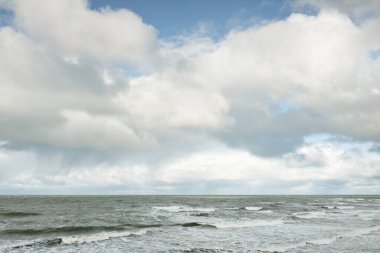 Fırtınadan sonra dramatik günbatımı bulutları altında Baltık Denizi. Dalgalar, su sıçratma. Destansı deniz manzarası. Kasırga, fırtına, sert hava, meteoroloji, ekoloji, iklim değişikliği, doğal olaylar