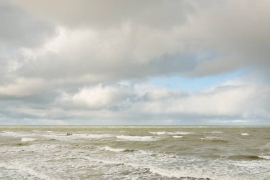 Fırtınadan sonra dramatik günbatımı bulutları altında Baltık Denizi. Dalgalar, su sıçratma. Destansı deniz manzarası. Kasırga, fırtına, sert hava, meteoroloji, ekoloji, iklim değişikliği, doğal olaylar
