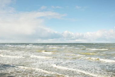 Fırtınadan sonra dramatik günbatımı bulutları altında Baltık Denizi. Dalgalar, su sıçratma. Destansı deniz manzarası. Kasırga, fırtına, sert hava, meteoroloji, ekoloji, iklim değişikliği, doğal olaylar