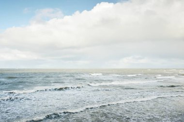 Fırtınadan sonra dramatik günbatımı bulutları altında Baltık Denizi. Dalgalar, su sıçratma. Destansı deniz manzarası. Kasırga, fırtına, sert hava, meteoroloji, ekoloji, iklim değişikliği, doğal olaylar
