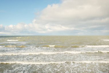 Fırtınadan sonra dramatik günbatımı bulutları altında Baltık Denizi. Dalgalar, su sıçratma. Destansı deniz manzarası. Kasırga, fırtına, sert hava, meteoroloji, ekoloji, iklim değişikliği, doğal olaylar