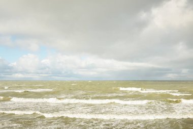 Baltic sea under dramatic sunset clouds after the storm. Waves, splashing water. Epic seascape. 40-50 knots wind force. Cyclone, gale, storm, rough weather, meteorology, ecology, climate change