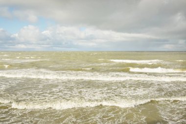 Fırtınadan sonra dramatik günbatımı bulutları altında Baltık Denizi. Dalgalar, su sıçratma. Destansı deniz manzarası. Kasırga, fırtına, sert hava, meteoroloji, ekoloji, iklim değişikliği, doğal olaylar