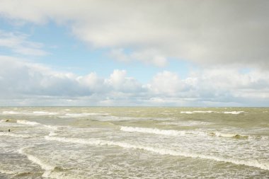 Fırtınadan sonra dramatik günbatımı bulutları altında Baltık Denizi. Dalgalar, su sıçratma. Destansı deniz manzarası. 40-50 deniz mili rüzgar gücü. Kasırga, fırtına, sert hava, meteoroloji, ekoloji, iklim değişikliği