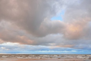 Gün batımında Baltık kıyısı. Kumsal manzarası (kum tepeleri). Dramatik günbatımı gökyüzü, parlayan bulutlar. Idyllic manzara. Doğa, tatiller, eğlence. Çevre turizmi. Panoramik görünüm