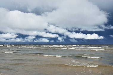 Fırtınadan sonra Baltık Denizi. Koyu mavi gökyüzü, çarpıcı parlayan bulutlar. Deniz manzarası, bulutlar, doğa. Panoramik manzara. Ekoloji, iklim değişikliği, hava durumu, tehlike