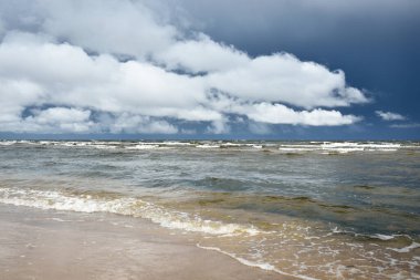 Fırtınadan sonra Baltık Denizi. Koyu mavi gökyüzü, çarpıcı parlayan bulutlar. Deniz manzarası, bulutlar, doğa. Panoramik manzara. Ekoloji, iklim değişikliği, hava durumu, tehlike