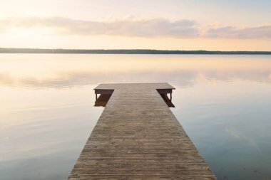 Orman Gölü (nehir) gün batımında. Ahşap iskele. Parlayan bulutlar, durgun ve berrak suda simetri yansımaları. Idyllic manzara. Doğa, ekoloji, ekolojik rezerv, eko-turizm, yürüyüş, tatiller