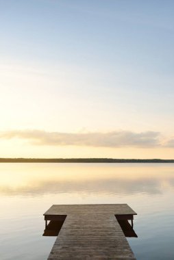 Orman Gölü (nehir) gün batımında. Ahşap iskele. Parlayan bulutlar, durgun ve berrak suda simetri yansımaları. Idyllic manzara. Doğa, ekoloji, ekolojik rezerv, eko-turizm, yürüyüş, tatiller