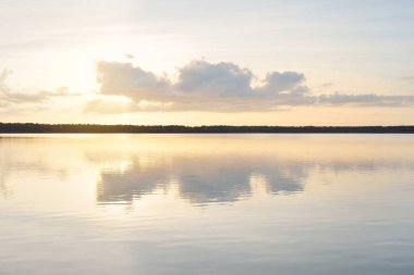 Orman Gölü (nehir) gün batımında. Parlayan bulutlar, berrak bir sudaki simetri yansımaları. Idyllic manzara. Resimli panoramik manzara. Saf doğa, ekoloji, ekolojik rezerv, eko-turizm.
