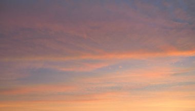 Parlayan pembe, altın rengi sirrus ve kümülüs bulutlarıyla açık mavi gökyüzü. Gün doğumu. Dramatik bulut manzarası. Sanat, meteoroloji, cennet, umut, barış, grafik kaynakları, resimli panoramik manzara