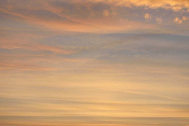 Parlayan pembe, altın rengi sirrus ve kümülüs bulutlarıyla açık mavi gökyüzü. Gün doğumu. Dramatik bulut manzarası. Sanat, meteoroloji, cennet, umut, barış, grafik kaynakları, resimli panoramik manzara