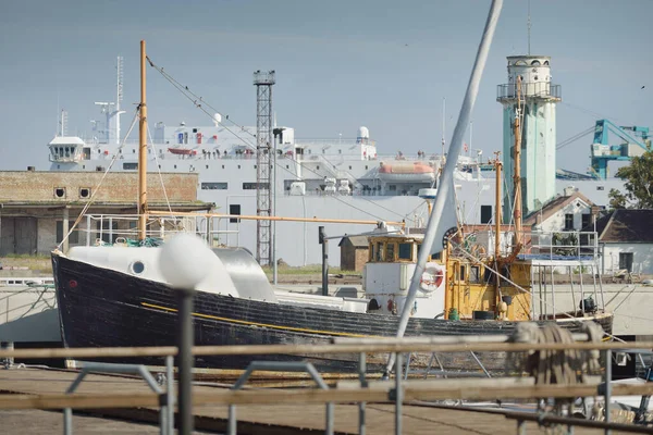 Eski bir ahşap klasik Kuzey Denizi balıkçı teknesi yat limanındaki bir rıhtıma demirlemiş. Denizcilik gemisi, ulaşım, geleneksel zanaat, sanayi