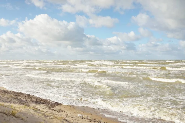 Fırtınadan sonra Baltık kıyıları (kum tepeleri, plaj). Dramatik gökyüzü, parlayan bulutlar. Resimli panoramik manzara. Doğa, çevre, ekoloji, eko-turizm, yürüyüş, keşif kavramları
