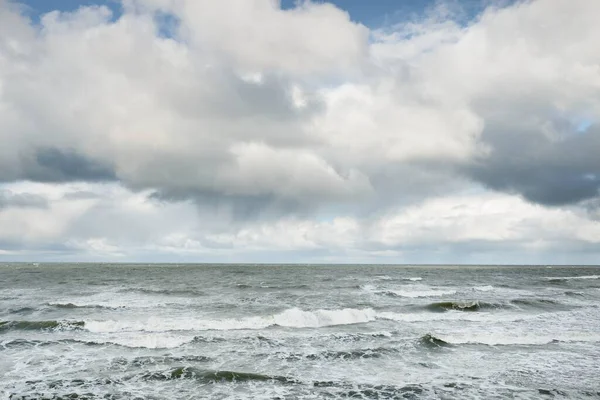 Fırtınadan sonra dramatik günbatımı bulutları altında Baltık Denizi. Dalgalar, su sıçratma. Destansı deniz manzarası. 40-50 deniz mili rüzgar gücü. Kasırga, fırtına, sert hava, meteoroloji, ekoloji, iklim değişikliği