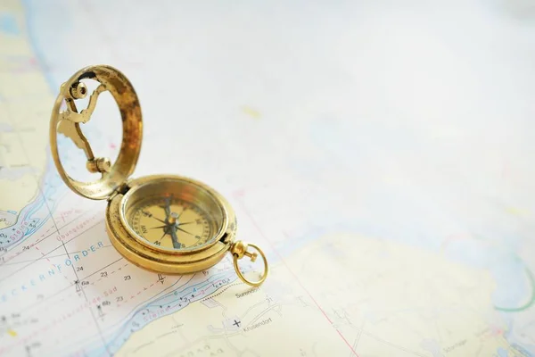 レトロなスタイルのアンティークゴールデンコンパス 日時計 と古い海図をクローズアップ ヴィンテージはまだ生きてる セーリングアクセサリー 旅行やナビゲーションのテーマ グラフィックリソース コピースペース — ストック写真
