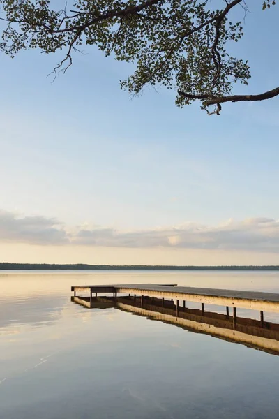 Orman Gölü (nehir) gün batımında. Ahşap iskele. Parlayan bulutlar, durgun ve berrak suda simetri yansımaları. Idyllic manzara. Doğa, ekoloji, ekolojik rezerv, eko-turizm, yürüyüş, tatiller