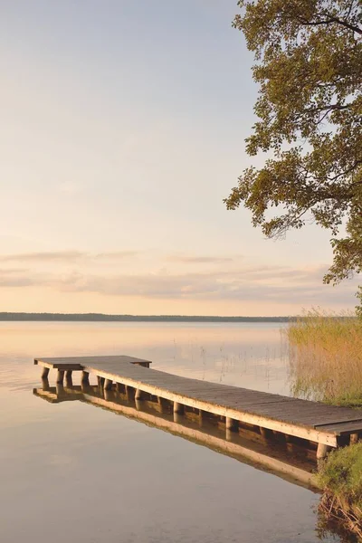 Orman Gölü (nehir) gün batımında. Ahşap iskele. Parlayan bulutlar, durgun ve berrak suda simetri yansımaları. Idyllic manzara. Doğa, ekoloji, ekolojik rezerv, eko-turizm, yürüyüş, tatiller