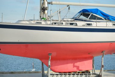 Bir yat limanında karada duran 20 metrelik bir yelkenli. Ulaşım, denizcilik, onarım ve hizmet, yelkencilik, spor, eğlence. Turizm, boş zaman aktivitesi kavramları