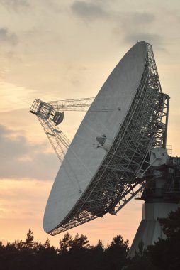 Büyük bir radyo teleskobu. Dramatik günbatımı gökyüzü, parlayan bulutlar. Doğa, hava, bilim, ekipman, teknoloji, uluslararası güvenlik, iletişim, uzak yerler