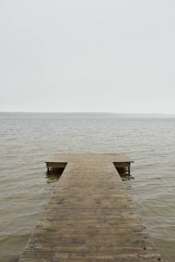 Yoğun bir siste orman nehri (göl). Ahşap iskele. Kasvetli gökyüzü, yağmur. Bulutlu bir gün. Idyllic manzara, kırsal manzara. Doğa, ekoloji, eko-turizm, yürüyüş, ekoloji beldesi, yerel turizm