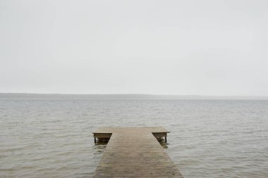 Yoğun bir siste orman nehri (göl). Ahşap iskele. Kasvetli gökyüzü, yağmur. Bulutlu bir gün. Idyllic manzara, kırsal manzara. Doğa, ekoloji, eko-turizm, yürüyüş, ekoloji beldesi, yerel turizm