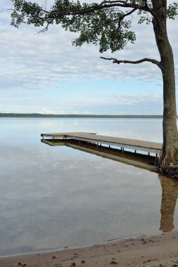 Orman nehri (göl) güneşli bir günde. Ahşap iskele. Clea gökyüzü, kristal berrak suda yansıyor. Idyllic manzara, kırsal manzara. Doğa, ekoloji, eko-turizm, yürüyüş, ekoloji beldesi, yerel turizm
