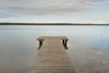 Orman nehri (göl) güneşli bir günde. Ahşap iskele. Clea gökyüzü, kristal berrak suda yansıyor. Idyllic manzara, kırsal manzara. Doğa, ekoloji, eko-turizm, yürüyüş, ekoloji beldesi, yerel turizm