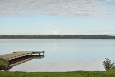 Orman nehri (göl) güneşli bir günde. Ahşap iskele. Clea gökyüzü, kristal berrak suda yansıyor. Idyllic manzara, kırsal manzara. Doğa, ekoloji, eko-turizm, yürüyüş, ekoloji beldesi, yerel turizm