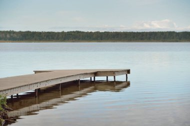 Orman nehri (göl) güneşli bir günde. Ahşap iskele. Clea gökyüzü, kristal berrak suda yansıyor. Idyllic manzara, kırsal manzara. Doğa, ekoloji, eko-turizm, yürüyüş, ekoloji beldesi, yerel turizm