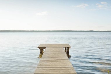 Orman nehri (göl) güneşli bir günde. Ahşap iskele. Clea gökyüzü, kristal berrak suda yansıyor. Idyllic manzara, kırsal manzara. Doğa, ekoloji, eko-turizm, yürüyüş, ekoloji beldesi, yerel turizm