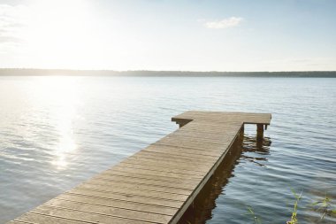 Orman nehri (göl) güneşli bir günde. Ahşap iskele. Clea gökyüzü, kristal berrak suda yansıyor. Idyllic manzara, kırsal manzara. Doğa, ekoloji, eko-turizm, yürüyüş, ekoloji beldesi, yerel turizm