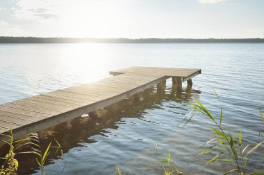 Orman nehri (göl) güneşli bir günde. Ahşap iskele. Clea gökyüzü, kristal berrak suda yansıyor. Idyllic manzara, kırsal manzara. Doğa, ekoloji, eko-turizm, yürüyüş, ekoloji beldesi, yerel turizm
