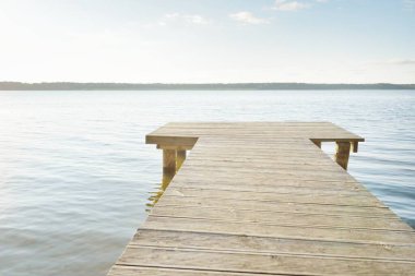 Orman nehri (göl) güneşli bir günde. Ahşap iskele. Clea gökyüzü, kristal berrak suda yansıyor. Idyllic manzara, kırsal manzara. Doğa, ekoloji, eko-turizm, yürüyüş, ekoloji beldesi, yerel turizm