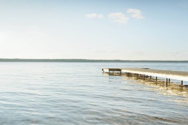 Orman nehri (göl) güneşli bir günde. Ahşap iskele. Clea gökyüzü, kristal berrak suda yansıyor. Idyllic manzara, kırsal manzara. Doğa, ekoloji, eko-turizm, yürüyüş, ekoloji beldesi, yerel turizm