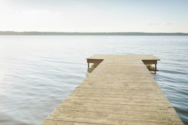 Orman nehri (göl) güneşli bir günde. Ahşap iskele. Clea gökyüzü, kristal berrak suda yansıyor. Idyllic manzara, kırsal manzara. Doğa, ekoloji, eko-turizm, yürüyüş, ekoloji beldesi, yerel turizm