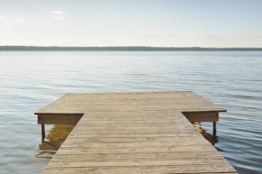 Orman nehri (göl) güneşli bir günde. Ahşap iskele. Clea gökyüzü, kristal berrak suda yansıyor. Idyllic manzara, kırsal manzara. Doğa, ekoloji, eko-turizm, yürüyüş, ekoloji beldesi, yerel turizm