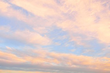 Gün batımında parlak pembe sirrus ve kümülüs bulutlarıyla açık mavi gökyüzü. Dramatik bulut manzarası. Sanat, meteoroloji, cennet, umut, barış, grafik kaynakları, resimli panoramik manzara