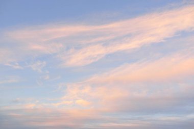 Gün batımında parlak pembe sirrus ve kümülüs bulutlarıyla açık mavi gökyüzü. Dramatik bulut manzarası. Sanat, meteoroloji, cennet, umut, barış, grafik kaynakları, resimli panoramik manzara