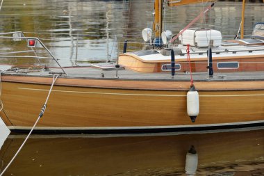 Modern classic wooden swedish cruising sailboat moored to a pier in a yacht marina. Tourism, vacations, leisure activity, recreation, sailing themes