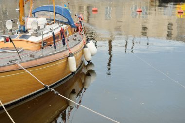 Modern klasik ahşap İsveçli yelkenli teknesi yat limanındaki bir iskeleye demirlemiş. Turizm, tatiller, boş zaman aktiviteleri, eğlence, yelkencilik temaları