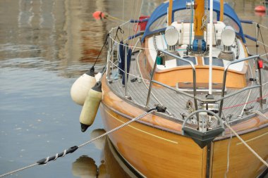 Modern klasik ahşap İsveçli yelkenli teknesi yat limanındaki bir iskeleye demirlemiş. Turizm, tatiller, boş zaman aktiviteleri, eğlence, yelkencilik temaları