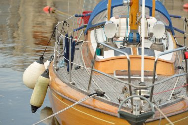 Modern klasik ahşap İsveçli yelkenli teknesi yat limanındaki bir iskeleye demirlemiş. Turizm, tatiller, boş zaman aktiviteleri, eğlence, yelkencilik temaları